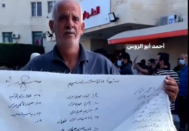 فلسطيني يكتب اسماء شهداء عائلته الذين قتلهم جيش الاحتلال بعد قصف منازلهم